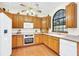 Bright kitchen with oak cabinets, white appliances, and a large window at 340 Plantation Club Dr, Debary, FL 32713