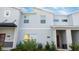 Two-story townhome with gray siding, red door, and landscaping at 4447 Scene Ln, Kissimmee, FL 34746