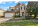 Charming two-story home with stone and brick accents, a well-manicured lawn, and an attached two-car garage at 4943 Cains Wren Trl, Sanford, FL 32771