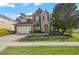 Charming two-story home with stone and brick accents, a well-manicured lawn, and an attached two-car garage at 4943 Cains Wren Trl, Sanford, FL 32771