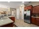 Bright kitchen features tile floors, stainless steel refrigerator and wooden cabinets at 4943 Cains Wren Trl, Sanford, FL 32771