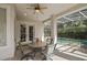 Covered patio with a round table and chairs next to a pool enclosure at 4943 Cains Wren Trl, Sanford, FL 32771