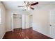 Bedroom with wood-look floors, ceiling fan and closet with open doors at 5112 Londonderry Blvd, Orlando, FL 32808