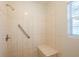 Tiled shower with showerhead, grab bar, tiled bench and natural light at 5112 Londonderry Blvd, Orlando, FL 32808