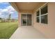 A covered back patio featuring a sliding glass door with serene views of the lawn at 523 Lazio Cir, Debary, FL 32713