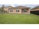 Beautiful fenced backyard with a lush green lawn and a covered patio at 523 Lazio Cir, Debary, FL 32713