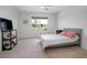 Bright bedroom featuring neutral decor, a ceiling fan, and a view to the outdoors at 523 Lazio Cir, Debary, FL 32713