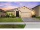 Charming single-story home featuring a well-manicured lawn, a two-car garage, and lovely landscaping at 523 Lazio Cir, Debary, FL 32713