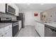 Modern kitchen featuring granite countertops, white cabinets, stainless steel appliances, and tile flooring at 523 Lazio Cir, Debary, FL 32713