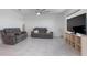 Bright living room with tile floors, featuring comfortable seating, a ceiling fan, and a large TV screen at 523 Lazio Cir, Debary, FL 32713