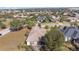 An aerial view of a residence with a large backyard surrounded by mature trees in a vibrant neighborhood at 5400 Emerald Bay Ln, Lady Lake, FL 32159