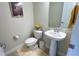 Small powder room with pedestal sink and toilet at 7613 Wandering Way, Orlando, FL 32836