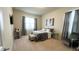 Bedroom with a queen-size bed, gray bedding, and a small seating area at 7613 Wandering Way, Orlando, FL 32836