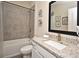 Bathroom with a shower-tub combination, granite countertop and a black framed mirror at 7958 Delwin Ln, Kissimmee, FL 34747