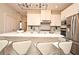 Modern kitchen with white cabinets, stainless steel appliances, an island with seating and stylish pendant lighting at 7958 Delwin Ln, Kissimmee, FL 34747