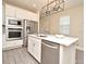 Modern kitchen features an island, stainless steel appliances, white cabinets, and wood-look flooring at 7958 Delwin Ln, Kissimmee, FL 34747