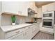 Well-appointed kitchen with stainless steel appliances, white countertops, gray backsplash and ample cabinet space at 7958 Delwin Ln, Kissimmee, FL 34747