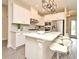 Modern white kitchen with stainless steel appliances, quartz countertops, and center island seating at 7958 Delwin Ln, Kissimmee, FL 34747