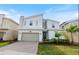 Two-story modern home with gray and white exterior, two-car garage, and landscaped lawn at 8828 Cruden Bay Ct, Davenport, FL 33896