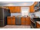 Kitchen with light wood cabinets, granite counters, and stainless steel appliances at 901 S Solandra Dr, Orlando, FL 32807