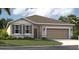 One-story home with gray siding, stone accents, and a two-car garage at 905 Pearlwood Loop, Eagle Lake, FL 33839