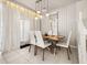 Dining area with a wood table, white chairs, and modern light fixture at 1366 Lava Tree Dr, Davenport, FL 33897