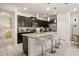 Modern kitchen with dark cabinetry, granite countertops, and an island with seating at 1366 Lava Tree Dr, Davenport, FL 33897