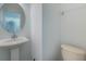 Small bathroom with pedestal sink, toilet, and vanity mirror at 13730 Lensdale Ln, Windermere, FL 34786
