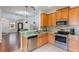 Kitchen with wood cabinets, stainless steel appliances, and green countertop at 13730 Lensdale Ln, Windermere, FL 34786