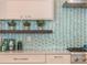 Kitchen backsplash with light green mosaic tiles and floating shelves at 141 Oakwood Way, Winter Park, FL 32789