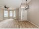 Bright living room with wood-look tile, ceiling fan, large windows, and modern chandelier at 1426 Madison Ivy Cir, Apopka, FL 32712