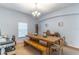 This dining room includes a large rustic table with bench seating and a view to the landscaped yard at 2048 Gloria Oak Ct, Orlando, FL 32820