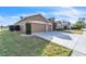 Tan house with a two-car garage and side yard at 245 Viola Dr, Auburndale, FL 33823