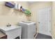 Laundry room with washer, dryer, utility sink, and shelving for storage at 245 Viola Dr, Auburndale, FL 33823