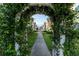 Scenic walkway framed by lush greenery and a white arbor, leading through the residential community at 2622 Lodi Cir # 103, Kissimmee, FL 34746