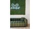 Stylish living space featuring a cozy green couch and a trendy grass wall with neon sign at 2622 Lodi Cir # 103, Kissimmee, FL 34746