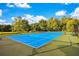 Bright blue community tennis court surrounded by lush greenery for outdoor play at 2622 Lodi Cir # 103, Kissimmee, FL 34746