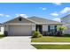 One-story home with a two-car garage, landscaping, and a neutral color palette at 3220 Sweet Acres Pl, St Cloud, FL 34772
