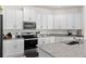 Modern kitchen with white cabinets and granite countertops at 3220 Sweet Acres Pl, St Cloud, FL 34772