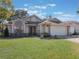 Tan single story house with a two car garage and manicured lawn at 349 New Waterford Pl, Longwood, FL 32779