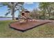 Community playground with slides and climbing features sits next to a lake on a grassy lawn at 349 New Waterford Pl, Longwood, FL 32779
