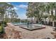 Relaxing community pool and spa surrounded by lounge chairs with a calming lake view at 349 New Waterford Pl, Longwood, FL 32779