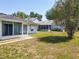 Rear exterior view of the home featuring a screened-in porch and compact back lawn at 511 Coventry Ct, Mount Dora, FL 32757