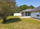 Back exterior featuring a screened-in porch and partially shaded lawn at 511 Coventry Ct, Mount Dora, FL 32757