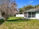 Back yard with lush grass, mature trees, and a white fence at 511 Coventry Ct, Mount Dora, FL 32757