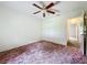 Bedroom with ceiling fan, closet, and view into the hallway at 511 Coventry Ct, Mount Dora, FL 32757