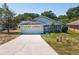 Charming single-story home with light blue siding, attached garage and inviting front yard at 511 Coventry Ct, Mount Dora, FL 32757