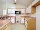 Compact kitchen featuring white cabinets and a black microwave, maximizing space for meal prep and efficiency at 511 Coventry Ct, Mount Dora, FL 32757