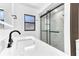 Modern bathroom with sleek, black-framed glass shower, large mirror, and marble countertops at 5300 Lido St, Orlando, FL 32807