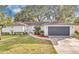 Updated single-story home with modern gray garage door and landscaped lawn at 5300 Lido St, Orlando, FL 32807